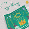 Signed copy of 'Children Illustrated Book - Living Hope: Cakuva and The Crown' featuring a colorful castle, crown, and gem-themed cover design.